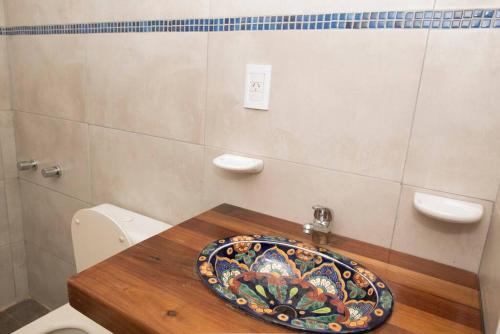 ein Badezimmer mit einem Mosaikwaschbecken auf einem WC in der Unterkunft Cabaña Nélida - Atlántida - Santa Clara del Mar in Santa Clara del Mar