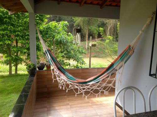 a hammock on the porch of a house at Recanto dos Amigos in Santa Teresa