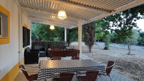 een patio met een tafel en stoelen en een piano bij São Cristóvão Farmhouse Setúbal in Setúbal