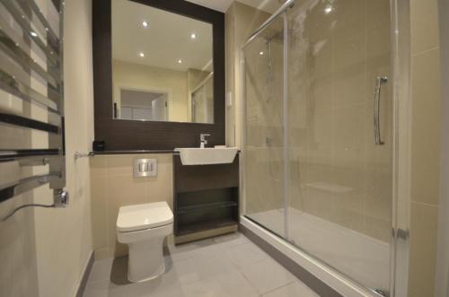 a bathroom with a toilet and a sink and a shower at Stunning Lake and City View 2BD/2BA in Kent