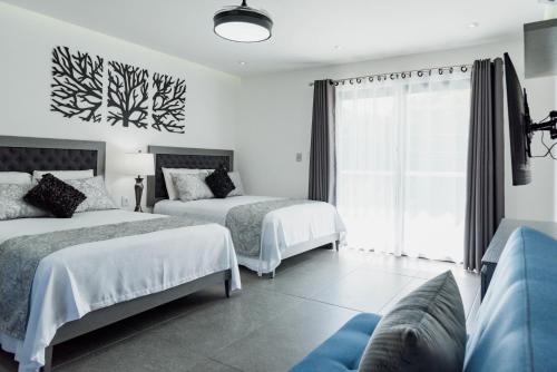 a bedroom with two beds and a window at Dreams Apartments 1 Loft a 9 minutos de la playa in Isla Mujeres