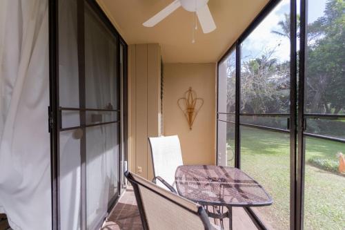 a patio with a table and a chair on a porch at Primrose Condo in Kahuku