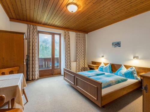 um quarto com uma cama grande e almofadas azuis em Ferienwohnungen-LIPPENHOF em Sankt Jakob in Defereggen