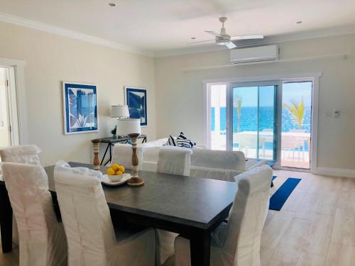 a dining room and living room with a table and chairs at Coral Point home in Governorʼs Harbour