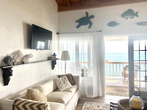 a living room with a couch and a view of the ocean at Blue Love Point 3BR home in Gregory Town