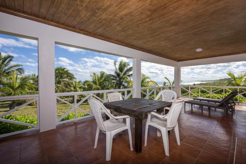 ein Esszimmer mit einem Tisch und Stühlen auf dem Balkon in der Unterkunft Atlantic Sunrise Villa villa in James Cistern