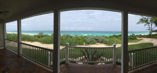 a screened porch with a view of the beach at French Leave South Beach Dogtrot Villa villa in Governorʼs Harbour