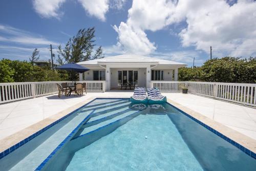 a swimming pool in front of a house at Come and Go Villa home in Hatchet Bay Limited Settlement