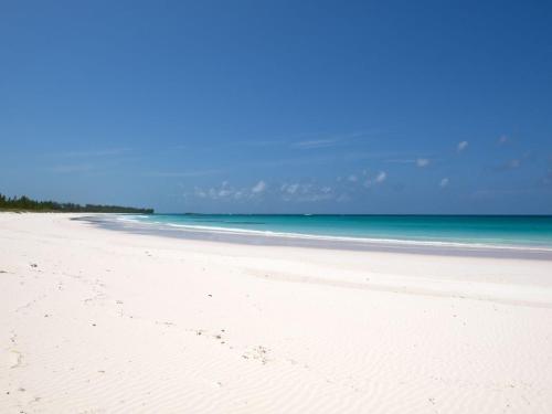 a white beach with the ocean in the background at French Leave South Beach Dogtrot Villa villa in Governorʼs Harbour