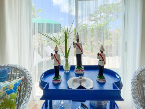 a blue table with two figurines on top of it at Folly Guest House cottage in Governorʼs Harbour