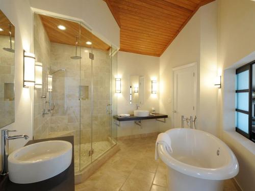 La salle de bains est pourvue d'une baignoire, d'une douche et d'un lavabo. dans l'établissement Sky Beach Club Bungalow cabin, à Governorʼs Harbour