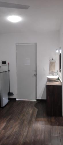 um quarto com uma casa de banho com um lavatório e uma porta em Estudio a 15 min caminando de la terminal de autobuses ADO em Cancún