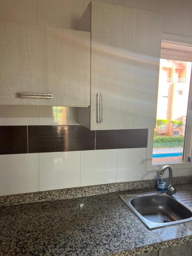 un bancone della cucina con lavandino e finestra di Ricoflores PALM a Ben Slimane