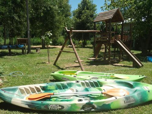 un grupo de kayaks sentados junto a un parque infantil en cabaña valhalla delta en tigre en Dique Luján