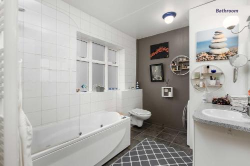 y baño con bañera, aseo y lavamanos. en Private room in Hafnarfjordur, en Hafnarfjördur
