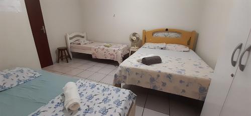 ein kleines Zimmer mit 2 Betten und einem Spiegel in der Unterkunft Chalé aconchegante na Barra de São Miguel in Barra de São Miguel