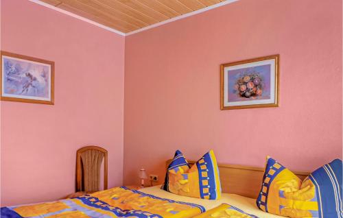 オストゼーバート・カールスハーゲンにある2 Bedroom Cozy Apartment In Karlshagenのベッドルーム1室(ベッド1台付)が備わります。壁に2枚の写真が飾られています。