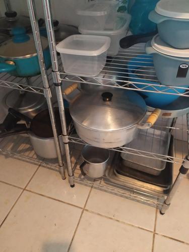 un estante de metal en una cocina con algunos platos en Casa 2 Recreio De Buzios 1 - casa em condomínio com vista para o mar, en Búzios