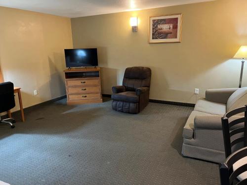 a living room with a tv and a couch and a chair at Americas Best Value Inn Pharr/McAllen in Pharr