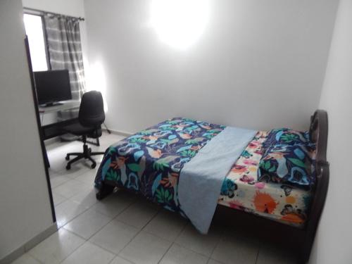Excelente ubicación في بوكارامانغا: غرفة نوم مع سرير ومكتب مع جهاز كمبيوتر