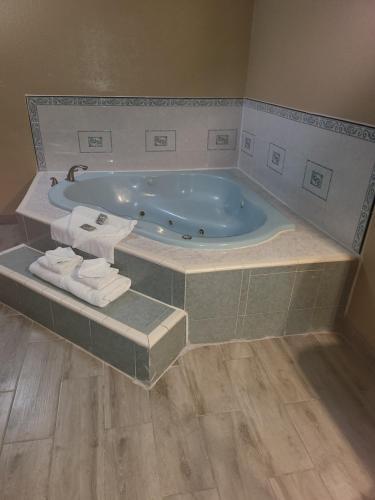 y baño con bañera grande y toallas. en Americas Best Value Inn Pharr/McAllen, en Pharr