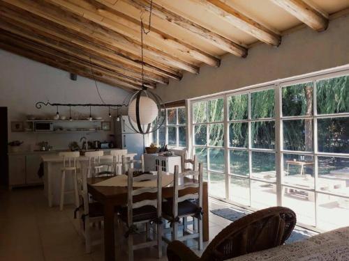 a dining room with a table and some windows at Casa Ramal in Ciudad Lujan de Cuyo