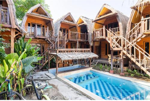 a resort with a swimming pool in front of a building at Deep House Bungalows in Gili Trawangan