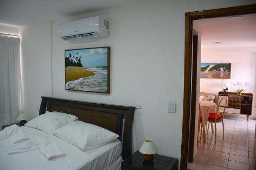 Un dormitorio con una cama y un comedor con una mesa. en Apto1003 - Conde da Praia - Vista Mar, en Natal