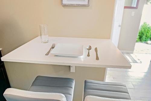 a white table with two chairs and a glass at THE COZY CORNER SUITE* *FAST WIFI* *278 Mbps* *30 MIN TO NYC in Unionport