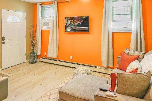 sala de estar con paredes de color naranja y sofá en THE COZY CORNER SUITE* *FAST WIFI* *278 Mbps* *30 MIN TO NYC, en Unionport