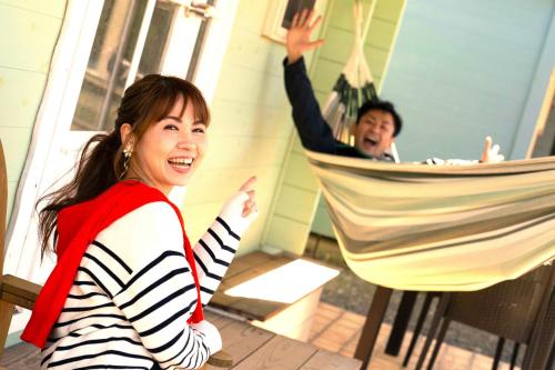 Cottage Morinokokage في ياكوشيما: امرأة تجلس على أرجوحة أمام مرآة