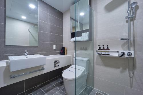 a bathroom with a toilet and a sink and a shower at Jeonju Signature Hotel&Residence in Jeonju