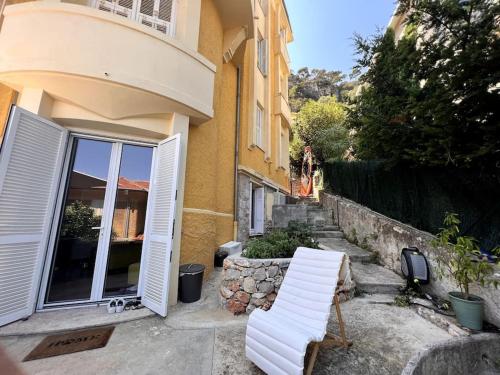 une paire de chaises blanches assises à l'extérieur d'un bâtiment dans l'établissement Magnifique appartement avec vue mer à Villefranche, à Villefranche-sur-Mer