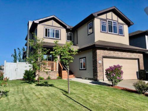 a large house with a garage in a yard at Luxury 3700 sq/ 5 bedroom/ jettedtub/ 4 fireplaces in Edmonton