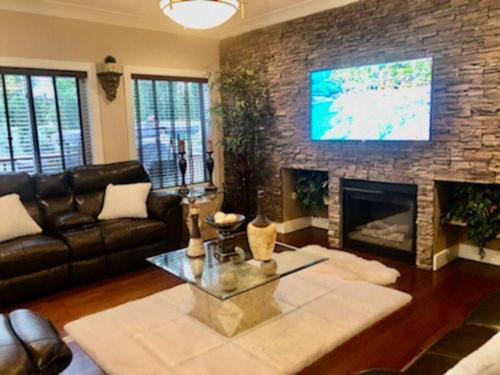a living room with a couch and a fireplace at Luxury 3700 sq/ 5 bedroom/ jettedtub/ 4 fireplaces in Edmonton