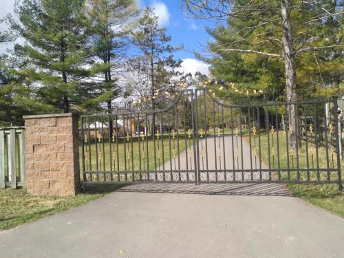 a black gate with a stone pillar in a park at Conservation lands family suite 2 rooms in Tottenham