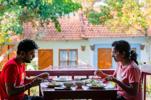 Een man en een vrouw die aan een tafel eten. bij Star Hill Village Resort Phu Quoc in Phu Quoc