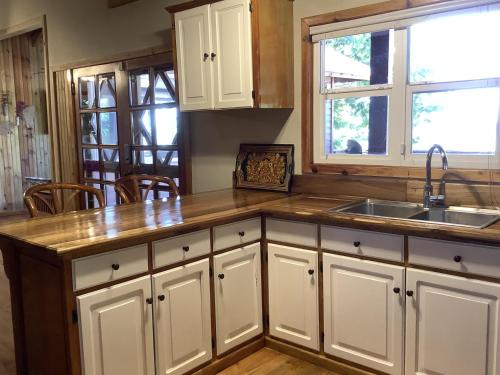 a kitchen with white cabinets and a sink at Reef Beach House - 2 Bedrooms and studio in Sandy Bay