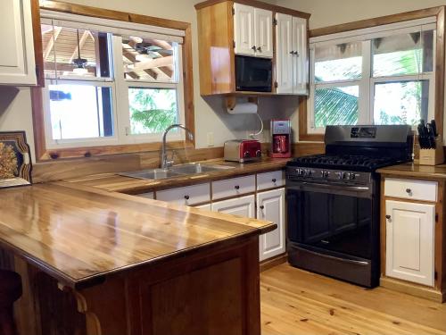 a kitchen with a sink and a stove top oven at Beachfront Home With Pristine, Calm Waters, White Sands And Unbelievable Sunset in Sandy Bay
