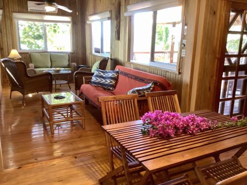 a living room with a table with flowers on it at Beachfront Home With Pristine, Calm Waters, White Sands And Unbelievable Sunset in Sandy Bay