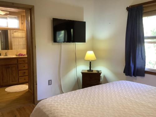a bedroom with a bed and a television on the wall at Beachfront Home With Pristine, Calm Waters, White Sands And Unbelievable Sunset in Sandy Bay