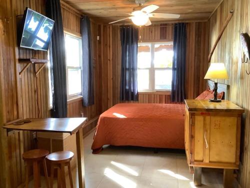 ein Schlafzimmer mit einem Bett und einem TV in der Unterkunft Reef Beach House - 2 Bedrooms and studio in Sandy Bay