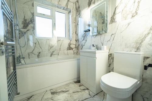 Newly Refurbished Modern 4 Bed Detached House ! في أوكسفورد: حمام مع مرحاض وحوض استحمام ومغسلة
