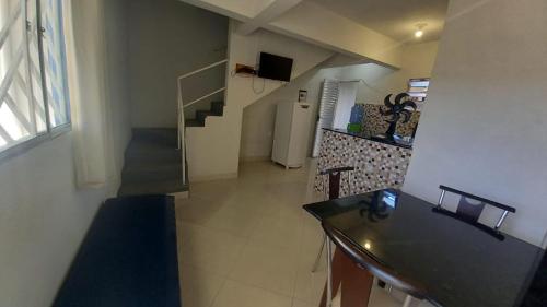 a room with a staircase and a kitchen with a table at Residencial Praia Quente casas in Nova Viçosa