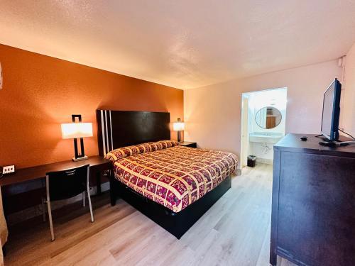 um quarto de hotel com uma cama e uma televisão em Economy Inn em Houma