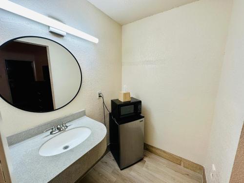 a bathroom with a sink and a mirror at Economy Inn in Houma
