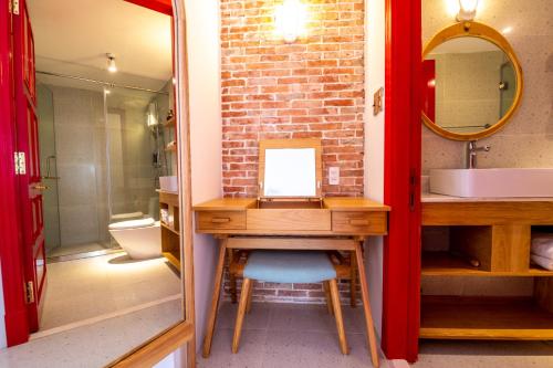 a bathroom with a sink and a vanity with a mirror at Leiden Homestay&Cafe' in Ho Chi Minh City