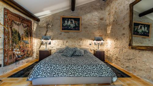 a bedroom with a bed and paintings on the walls at La Tour d'Enguernes in Montmeyan