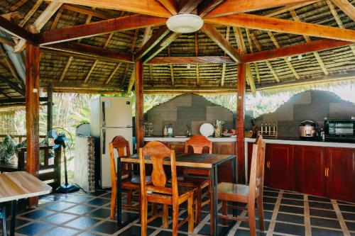 a dining room with a table and chairs and a kitchen at Palmera Palma Garden Level in Moalboal