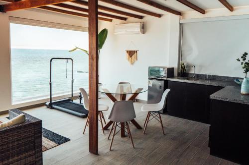 a kitchen with a table and a view of the ocean at Atenas Hotel Boutique in Paracas